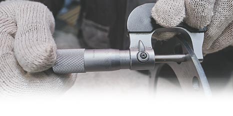 a person using a micrometer to measure the thickness of a piece of metal