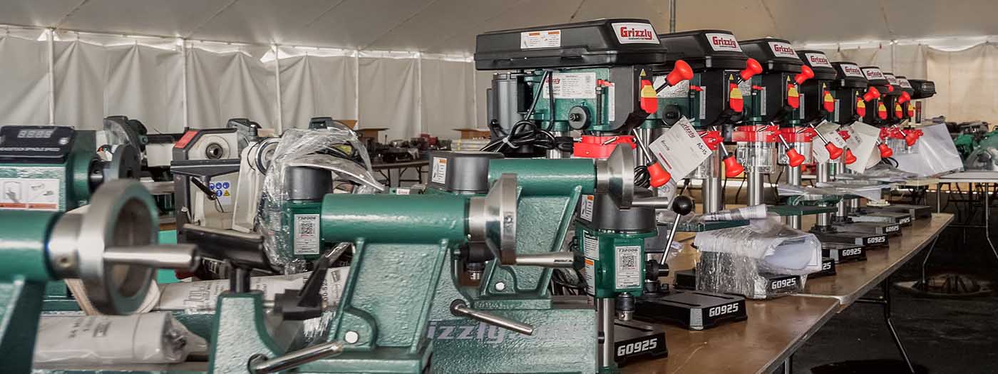 Wood lathes and drill presses lined up for sale in the tent